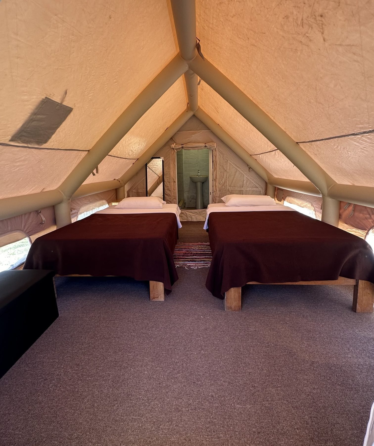 Interior de carpa doble con dos camas en el Glamping Antioquía